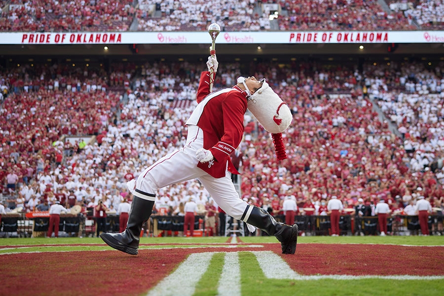 The Pride of Oklahoma's Drum Major marching on the Gaylord Family Oklahoma Memorial Stadium field.