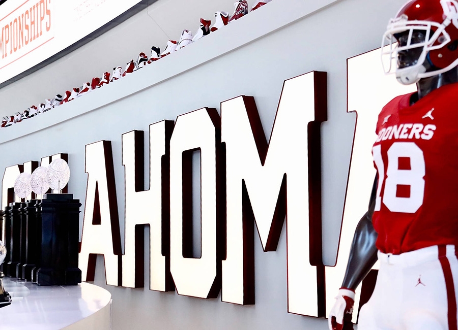 Trophies and a mannequin in OU football uniform on display at the Switzer Center.