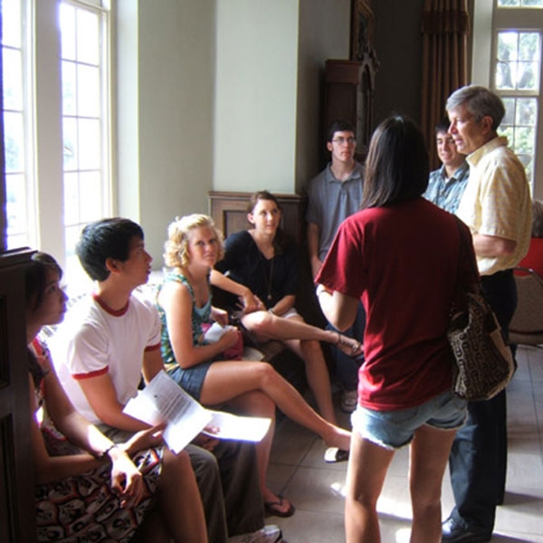 A faculty mentor talking to a group of students.
