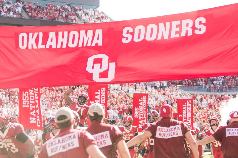 The Oklahoma Sooners football team rushes out to the field, greeted by over 88,000 passionate Sooner fans.