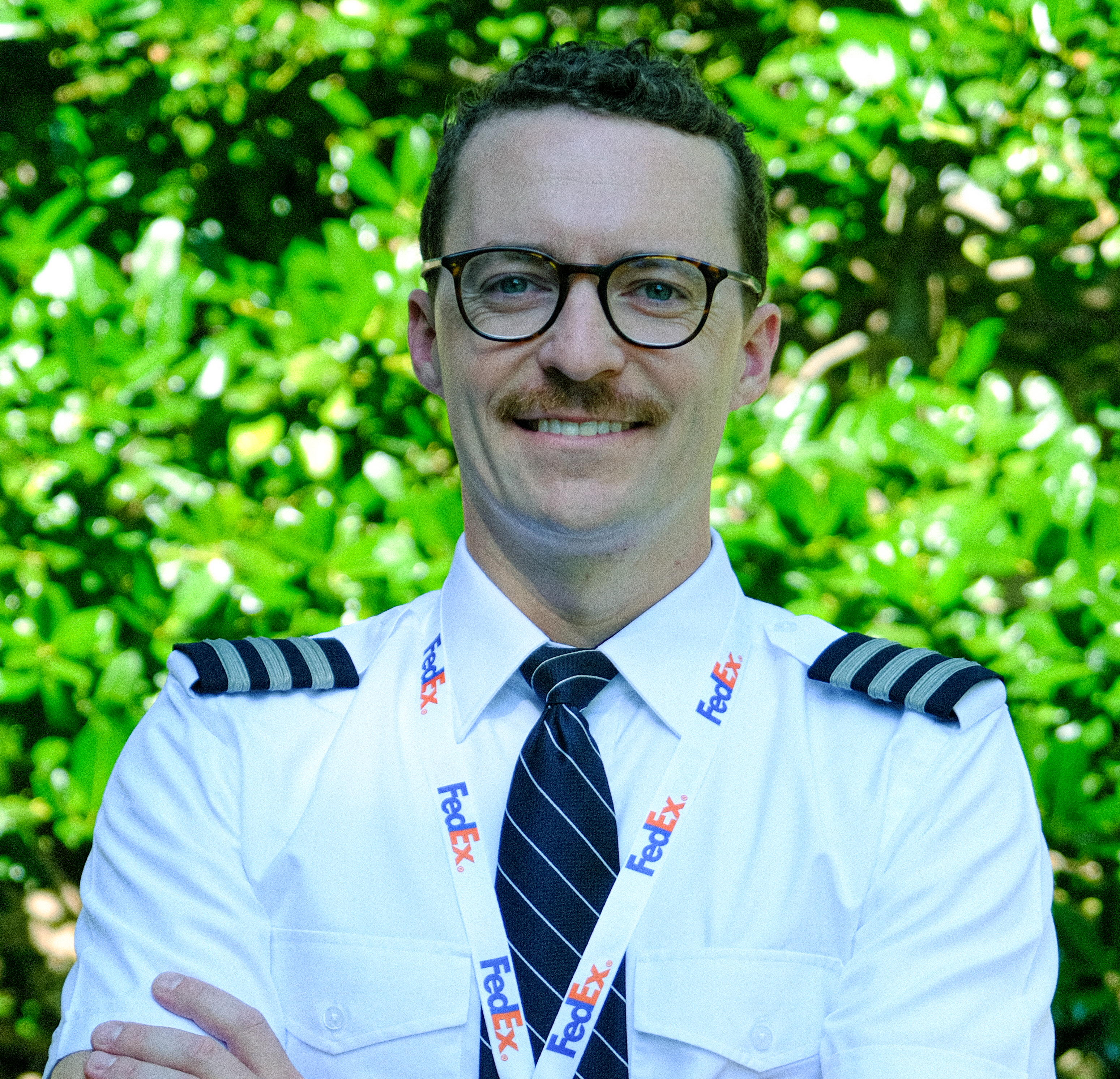 Tom Bishop, 航空学院 Studies Alumnus in his pilot's uniform  with his arms crossed.