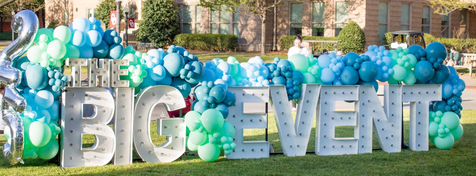 Three students hold up their gloved hands while volunteering at the 2018 Big Event.
