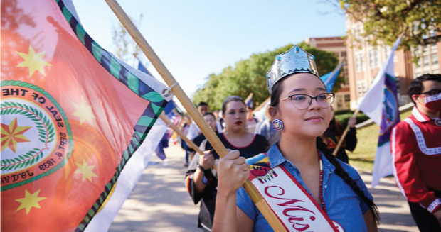 People with flags walking in a parade.