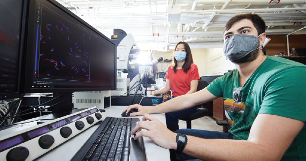 Two students working on a computer in a lab.