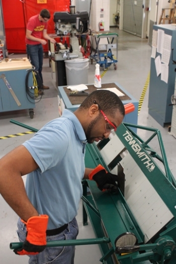 Student using sheet metal bender