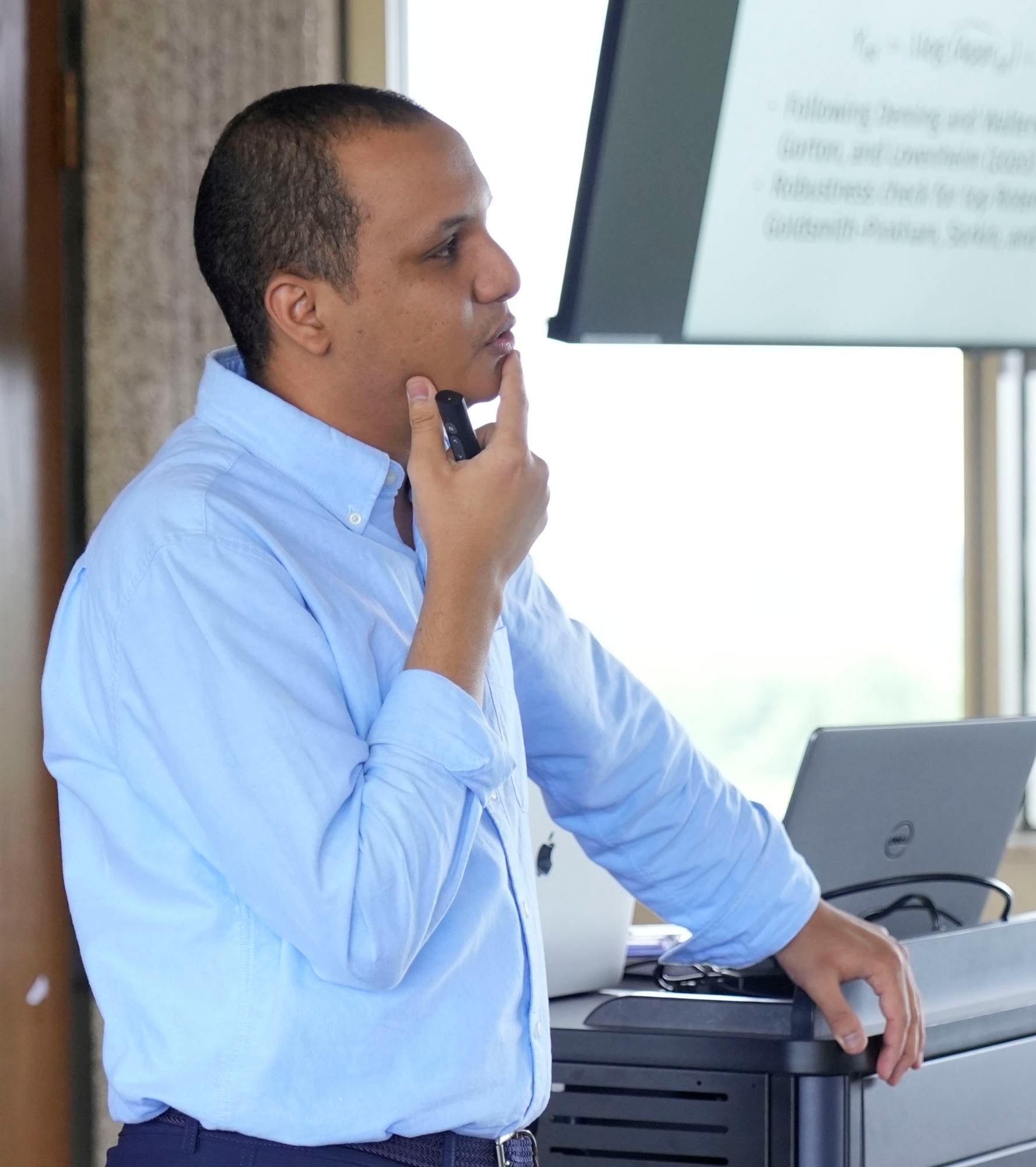 A man thinking about a question standing in front of a podium. 