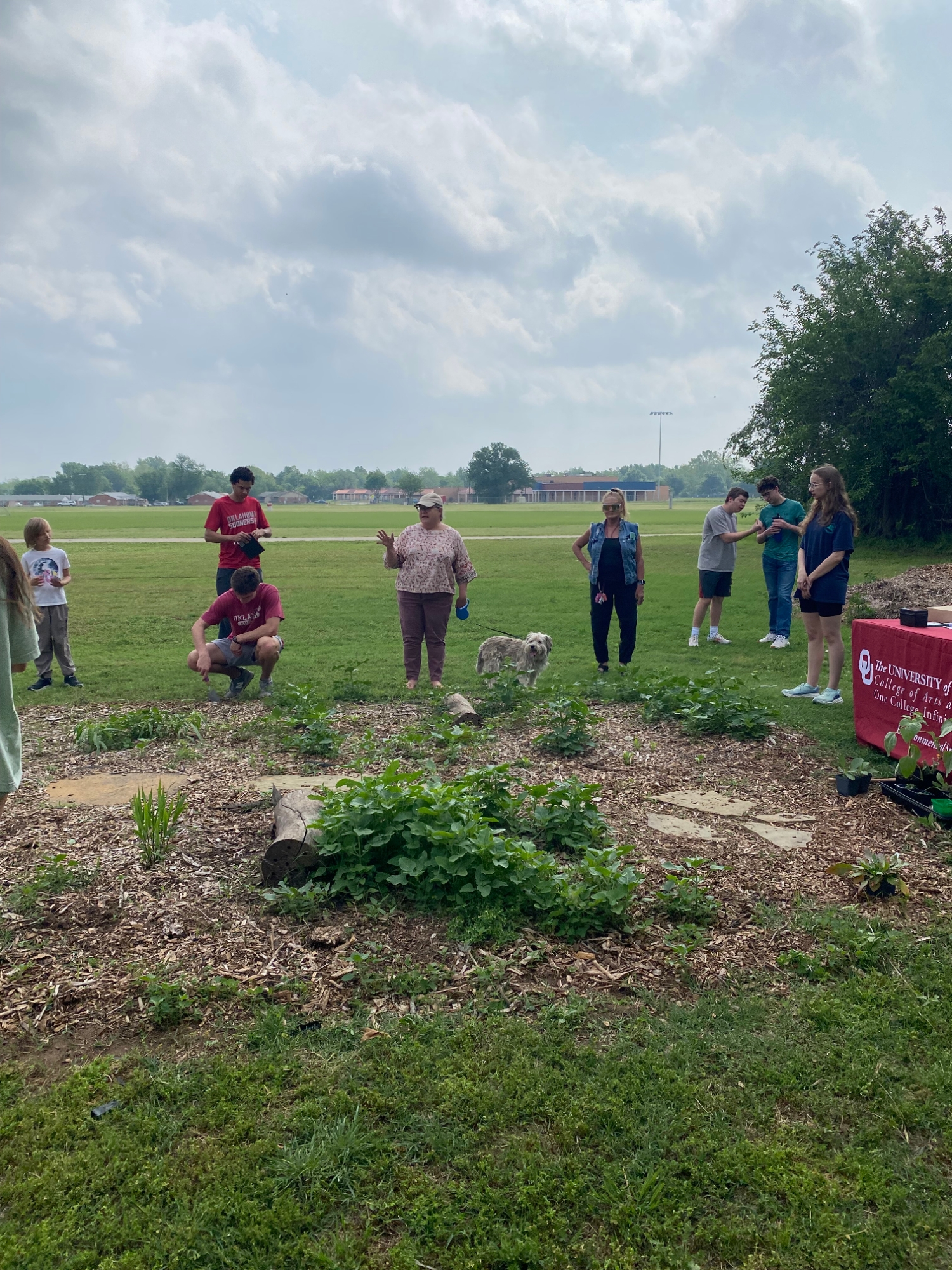 People and a dog gather at the pollinator garden.