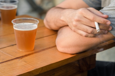 beer on a table person with a cigarette