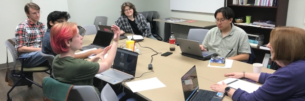 Photo of professor and six graduate students during class discussion