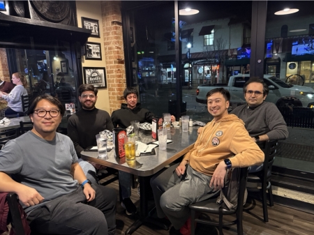 A small group from the High Energy Physics research group enjoying a meal at a restaurant.