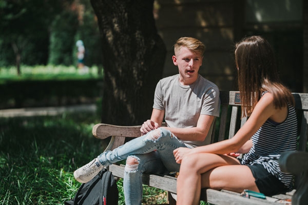 Students on bench in conversation.