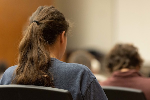 Student facing the front of a classroom.