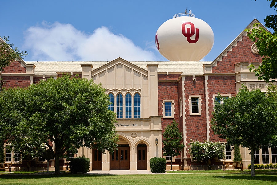 Wagner Hall with water tower against a blue sky with clouds.