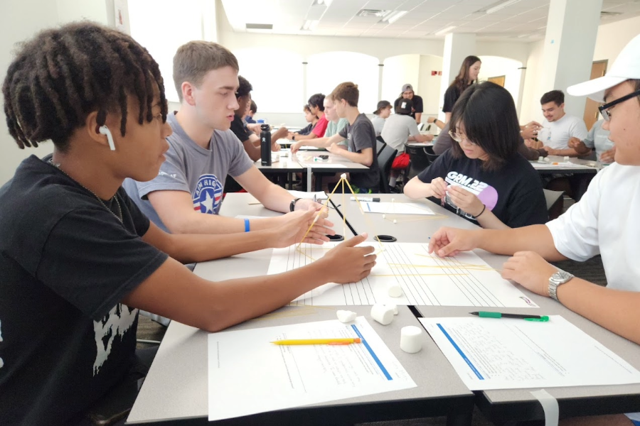 Students working on a project that involves using spaghetti to build a tower