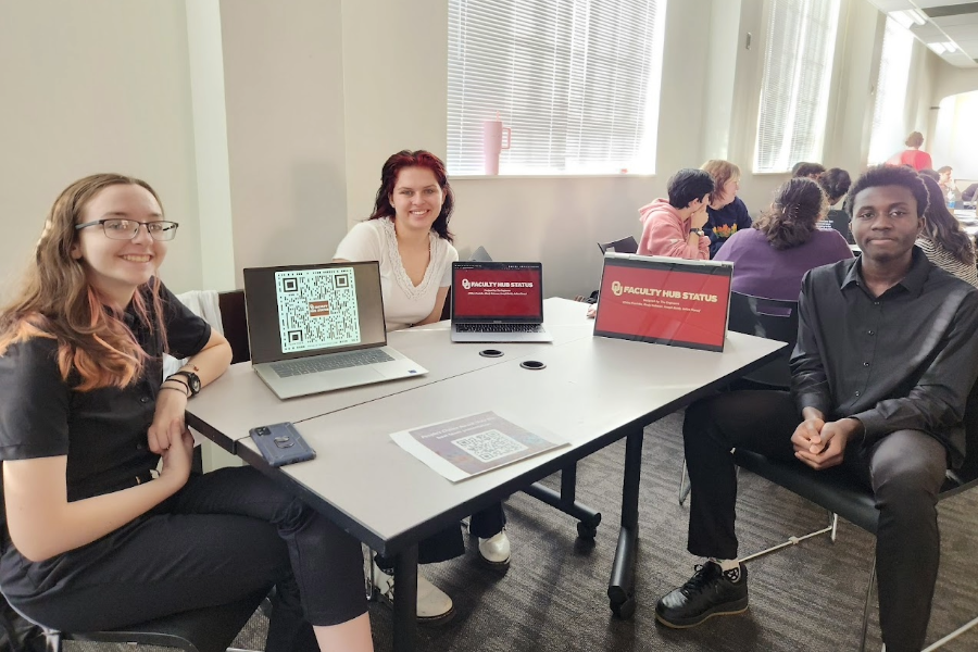 Students sitting around their project and smiling
