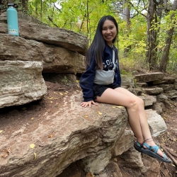 Lynn Nguyen sits on a rock
