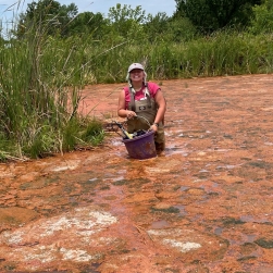 Sam Taylor carrying testing equipment throur the MRPTS ox-pond