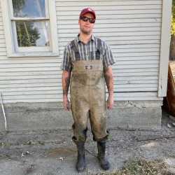 Leif Olson stands in muddy waders