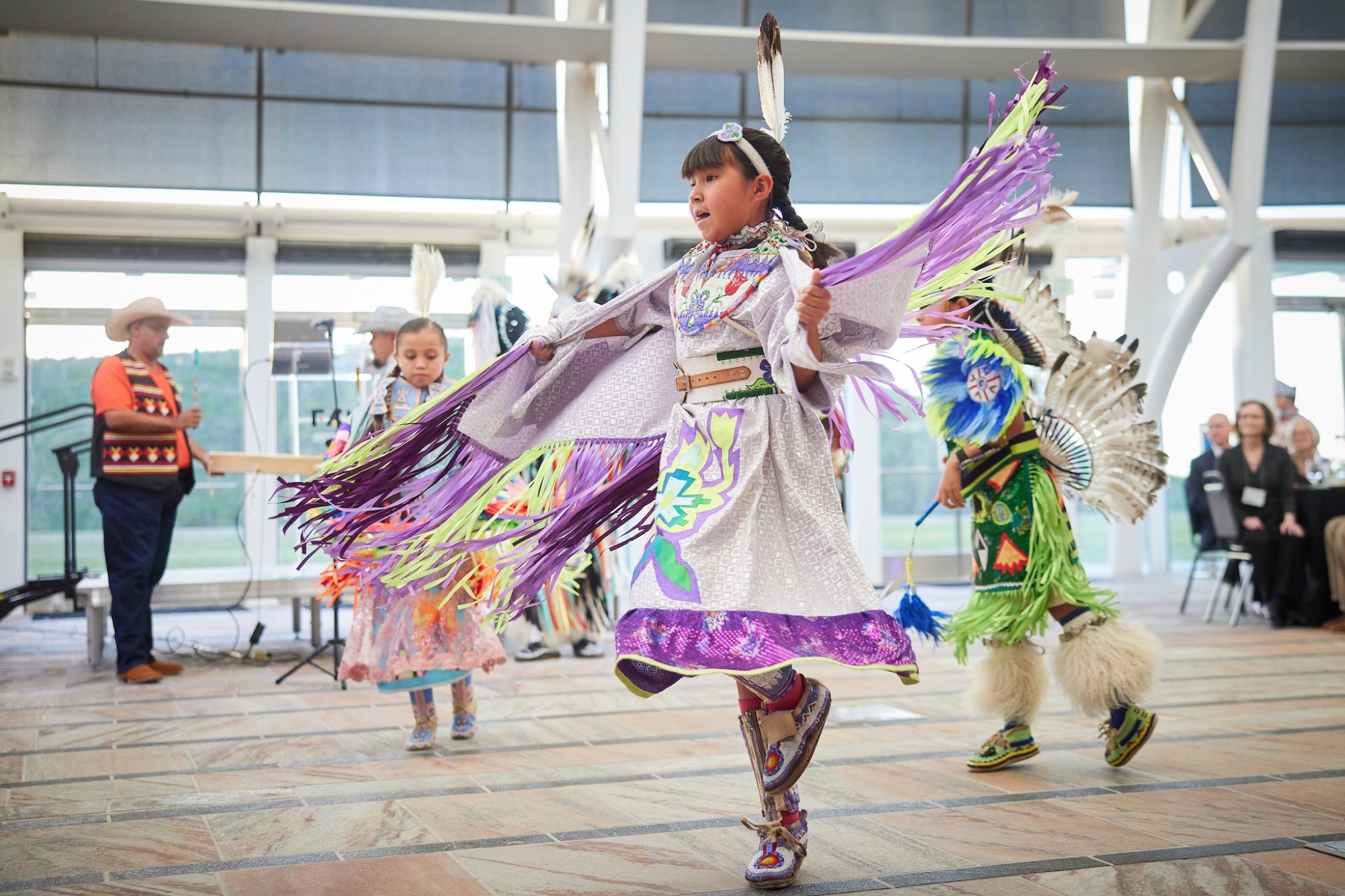 A group of children performing an indigenous dance in tribal attire.