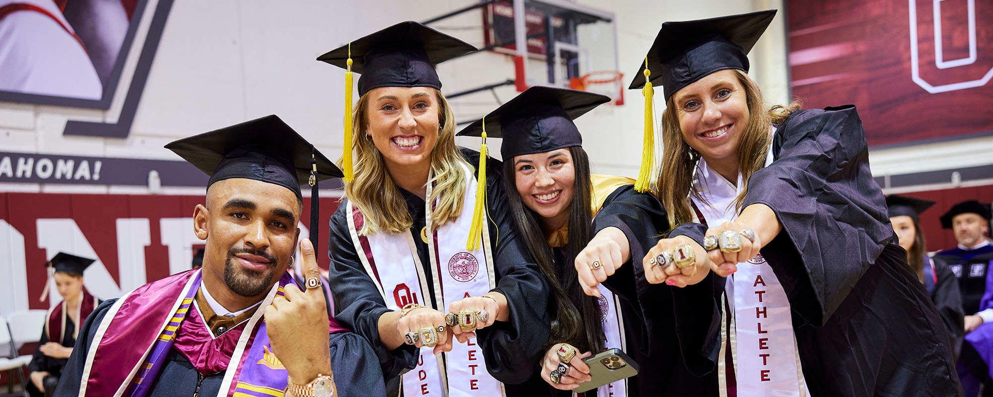Student athletes pose before graduation ceremony.