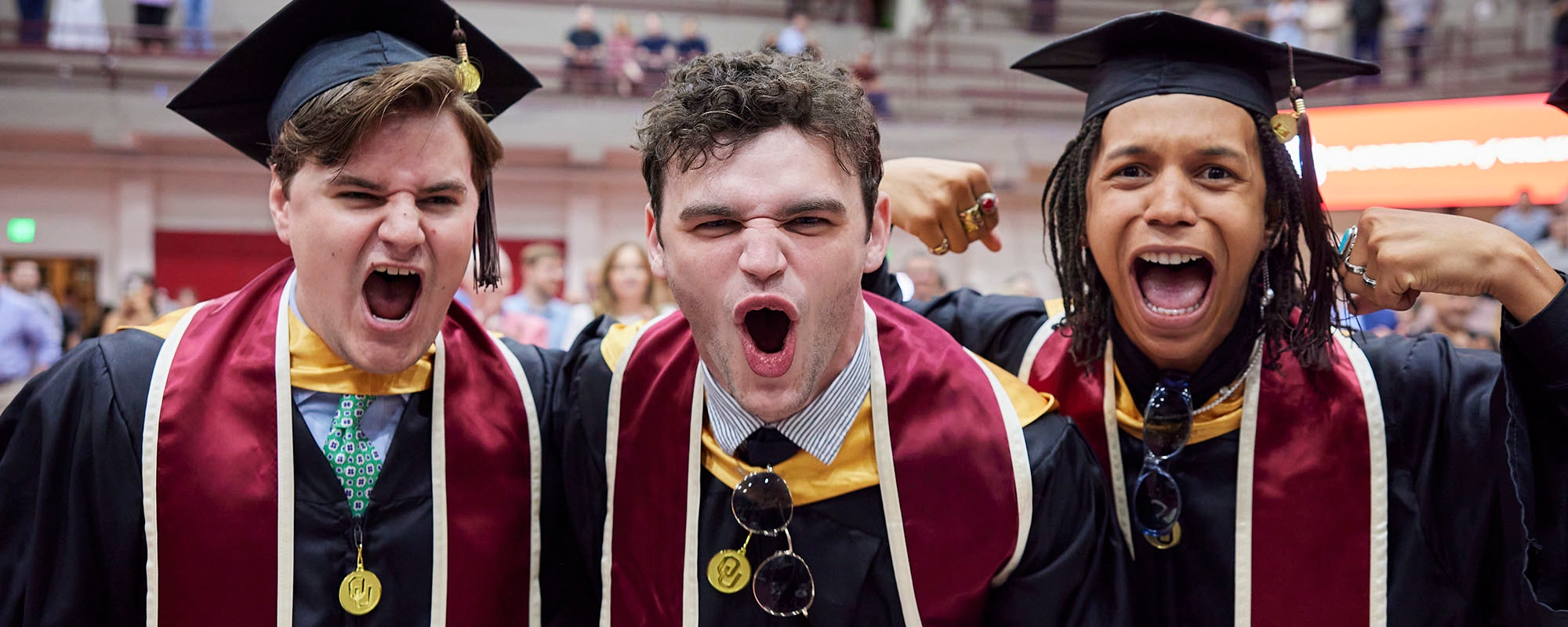Graduates celebrating during college convocation ceremony.