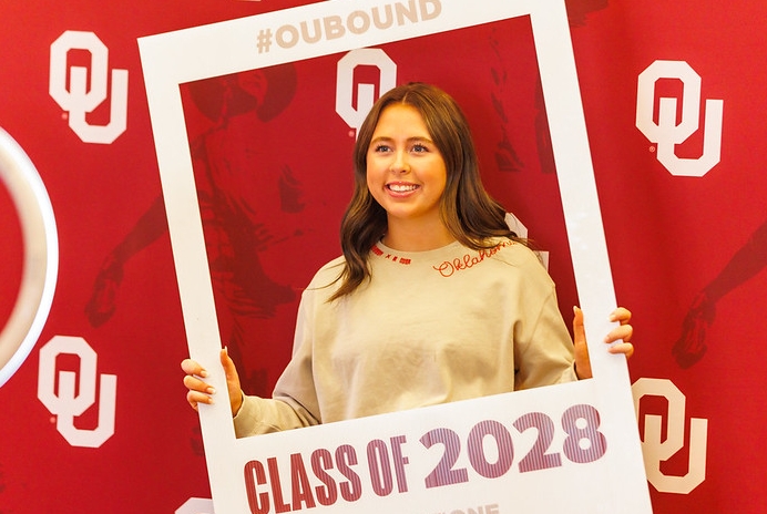 A student posing with a prop that looks like an polariod picture frame during admitted student day.