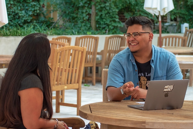 Two students speaking to each other outside of the Student Union.