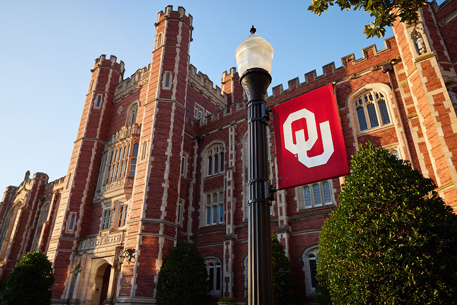 The exterior of Evans Hall, with a lamppost with OU flag in the foreground.