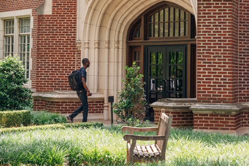 A student walking into Buchanan Hall.