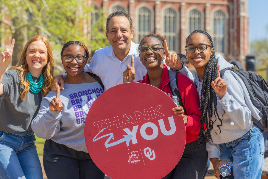 OU President Joseph Harroz stands with university community members, holding a sign that says "Thank You".