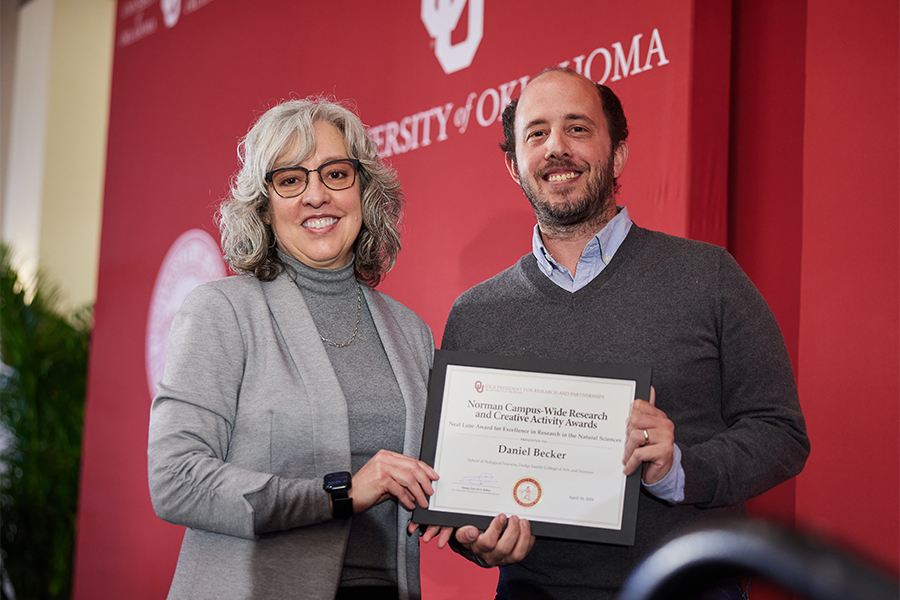 Daniel Becker receives an award from interim OU VPRP Carol Silva.