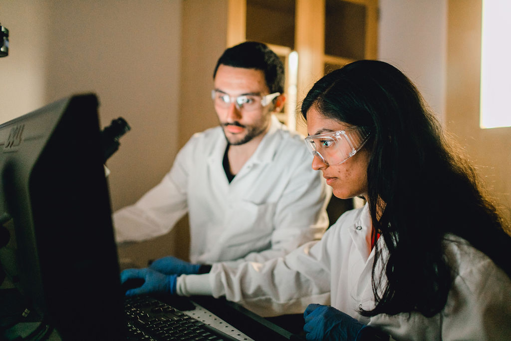 Two students working on a computer in a lab.