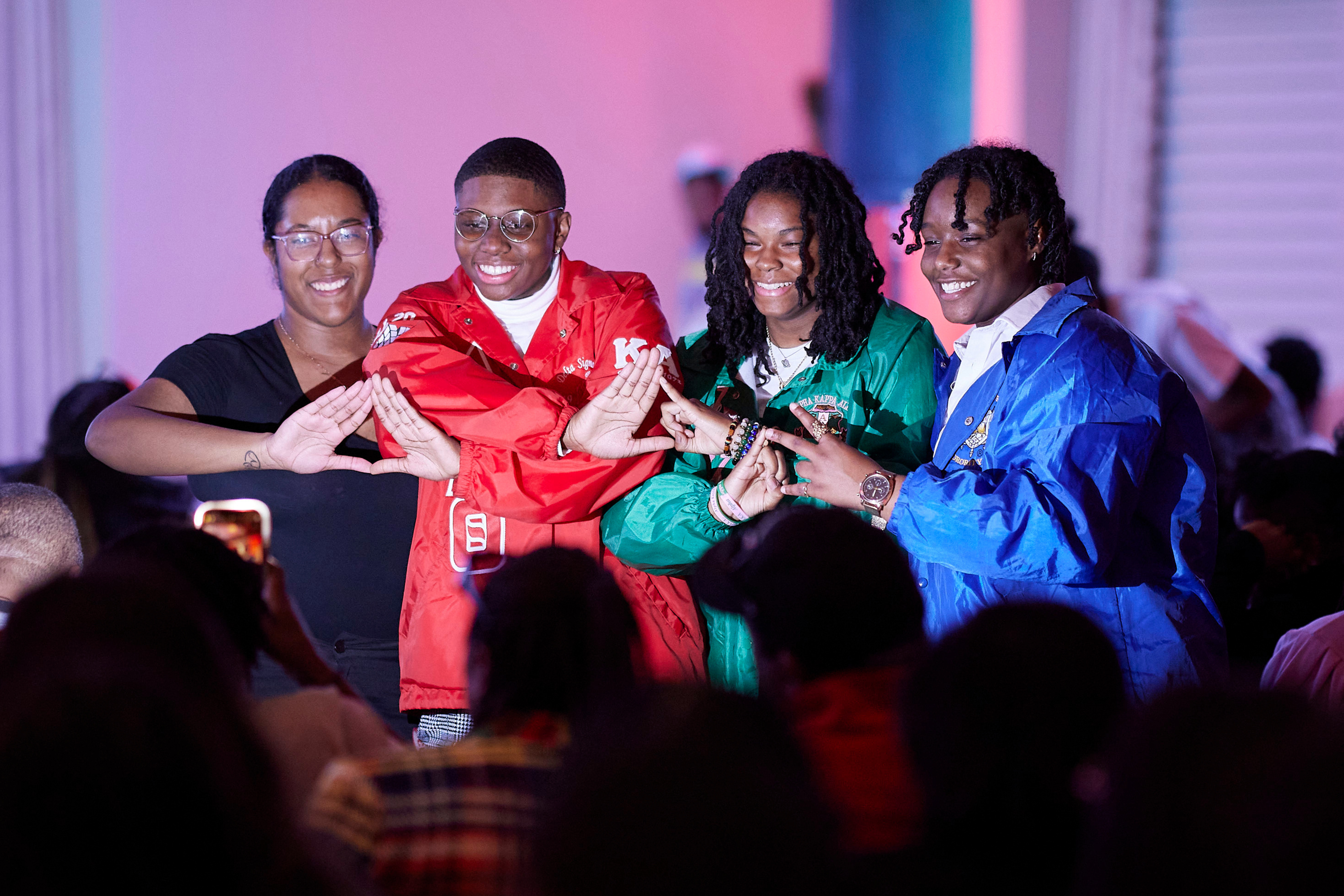 Students in historically black sororities doing organizational hand signs at Stompdown.