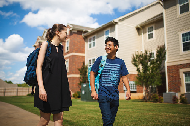 Two students walking outside a building.