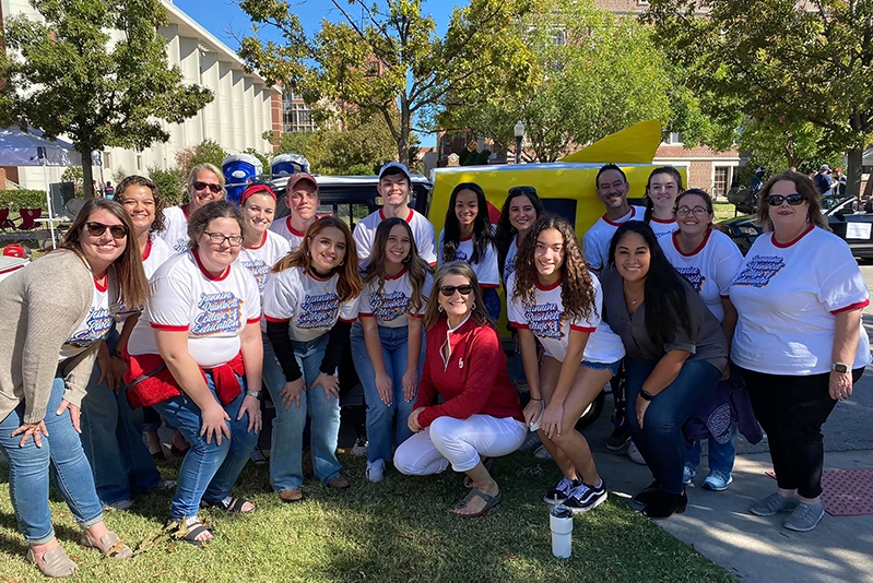 Students posing in front of the homecoming float