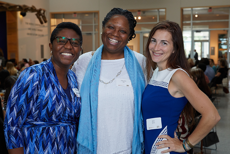 Three students standing and smiling at scholarship luncheon