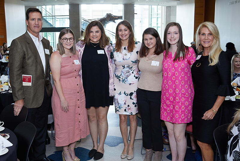 Two donors standing with five students at scholarship luncheon