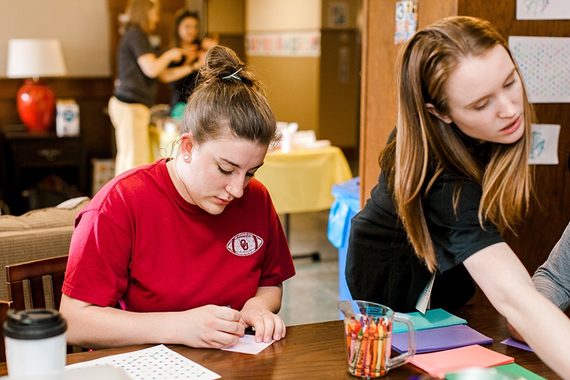 Two students working on crafts in Collings Hall lobby