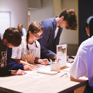 Group of four college students drawing with water color pencils. 