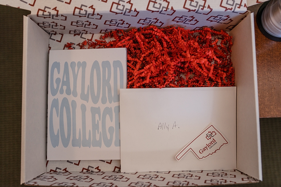 Gaylord college admission box with red confetti and gaylord college sticker