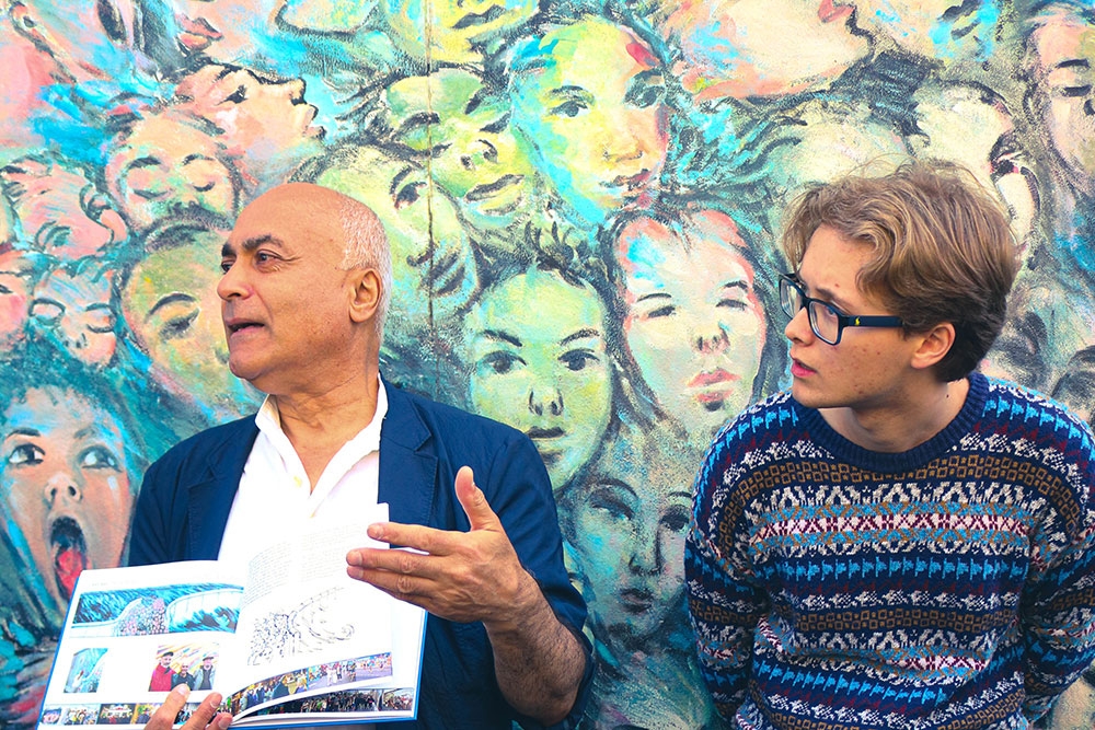 Kani Alavi and Noah Mack in front of an art installation at East Side Gallery in Berlin.