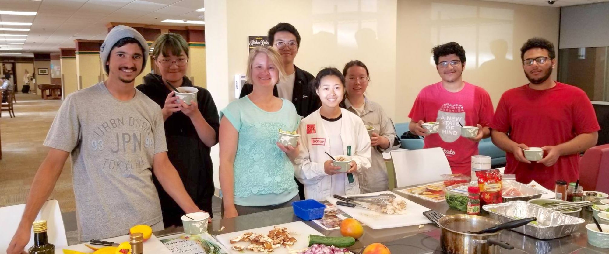 CESL students standing around a table with feed, meeting with a dietitian.