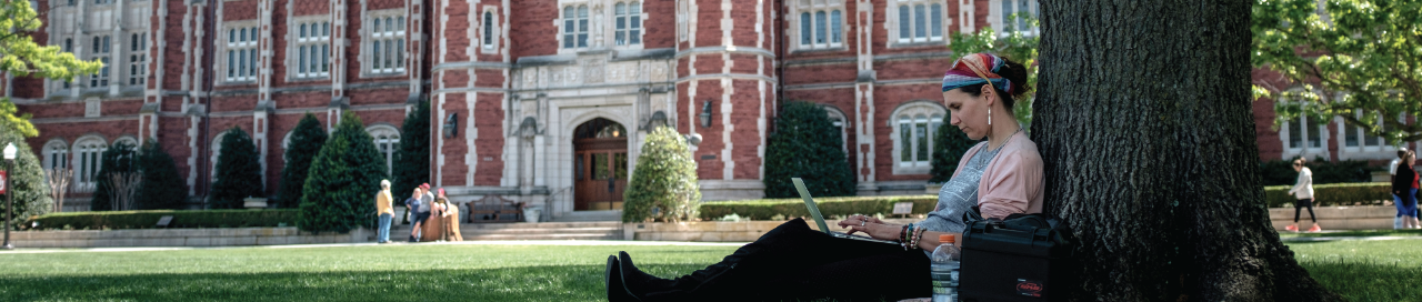 Girl sitting by tree on campus