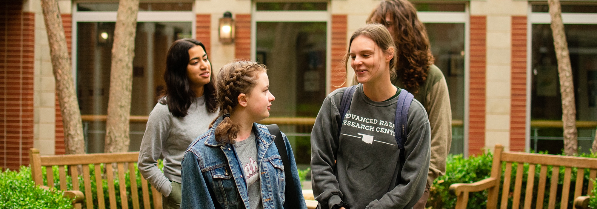 Four students talking in a courtyard.