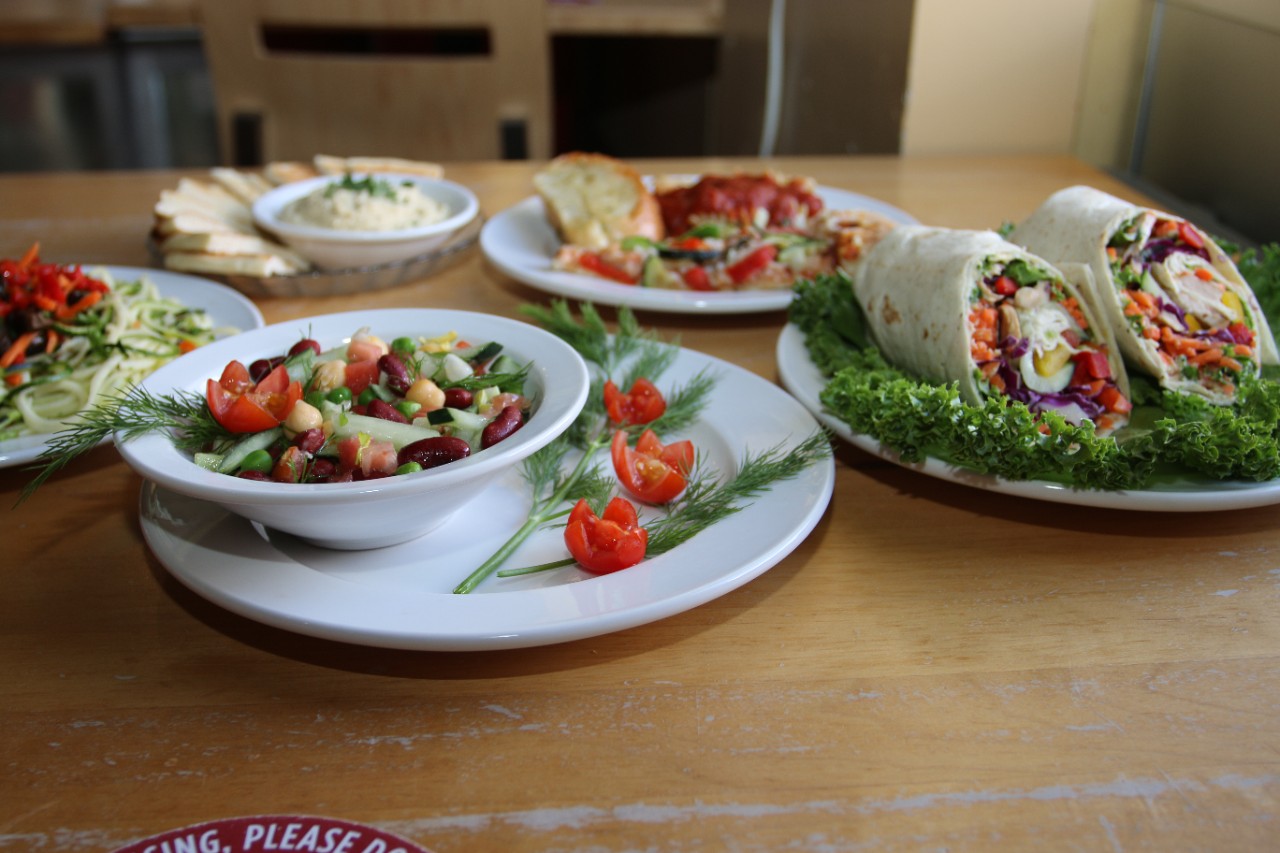 assorted vegan entrees on plates sitting on a table