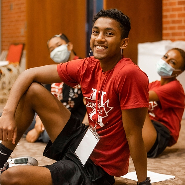 Student sits on floor at HSP event