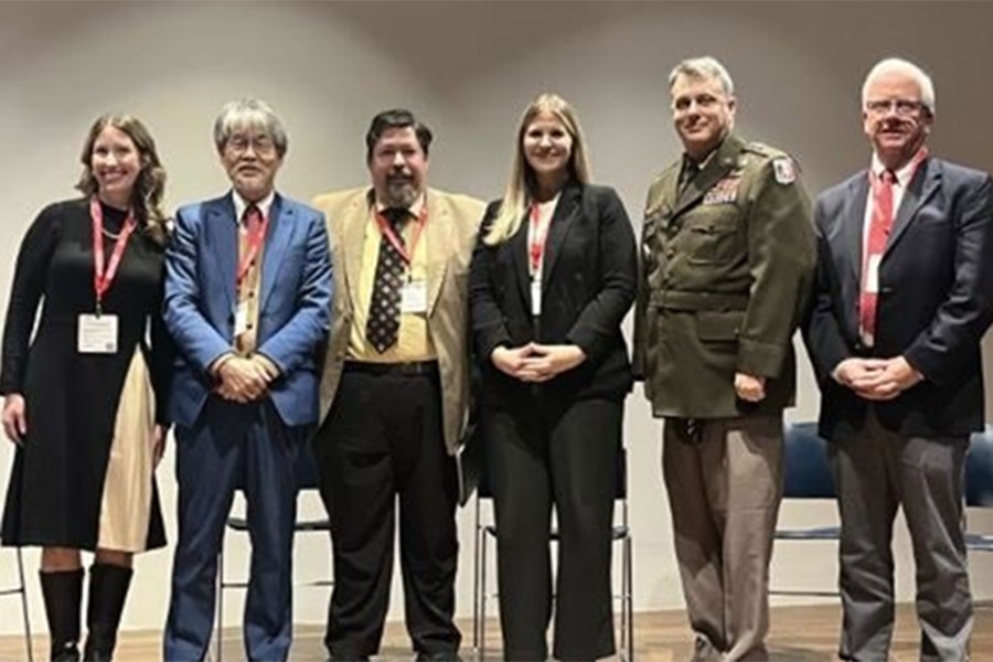 Symposium hosts and presenters pose for a photo.