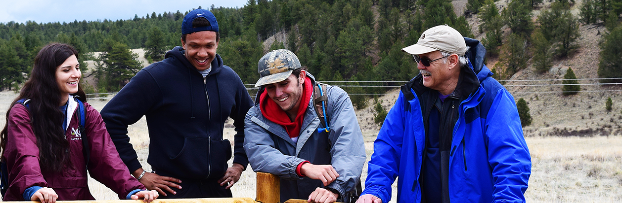 Group of student and faculty member laughing on a field trip.