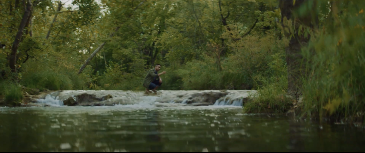 Delcio collecting a water sample in a creek.