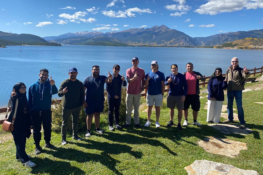 A group of students in front of a lake.
